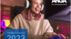 Titelblatt des Tätigkeitsberichts 2023 von ANGA Der Breitbandverband. Eine junge Frau mit weißen On-Ear-Kopfhörern lacht, während sie auf den Bildschirm schaut und die Tastatur benutzt - sie spielt offensichtlich. Leuchtlinien im Hintergrund als Symbol für die Telekommunikationsnetze.